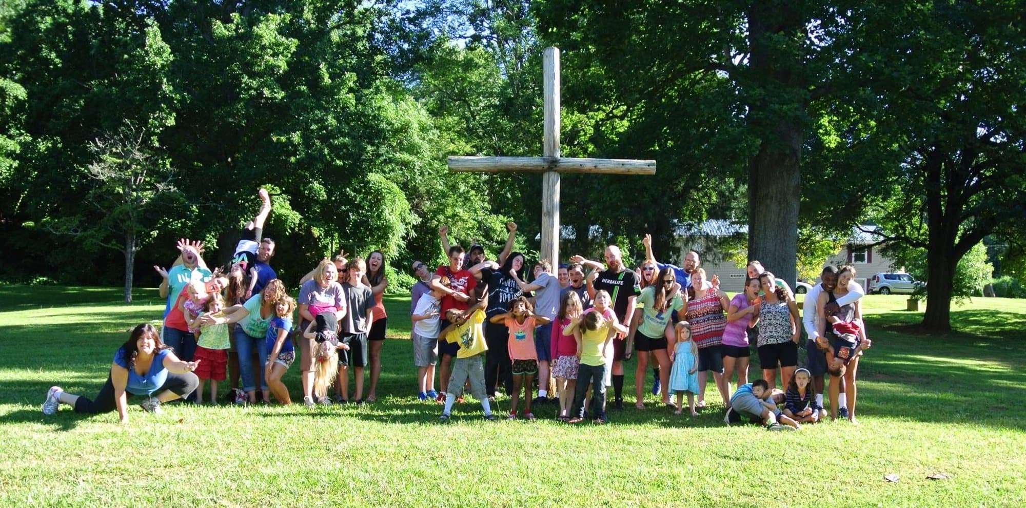 A group gathered at the cross on the lawn at Springs of Life Camp